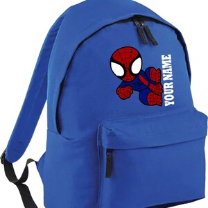 May include: Blue backpack featuring a cartoon Spider-Man graphic. The backpack has a front pocket and two zippered compartments. The text "YOUR NAME" is printed vertically on the side. The Spider-Man graphic is red, blue, and white.
