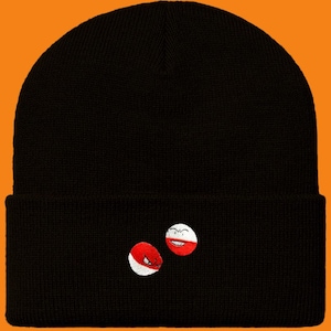Può includere: Berretto nero con un designo ricamato bianco e rosso di due facce di cartoni animati. Le facce sorridono e hanno uno schema di colori rosso e bianco.