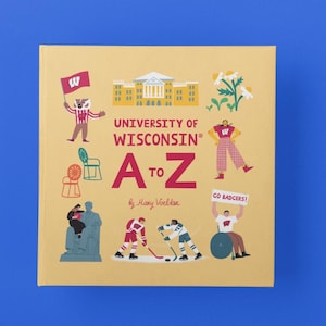 May include: A yellow book cover with the title "University of Wisconsin A to Z" by Mary Voelker. The cover features illustrations of a university building, a badger mascot, a chair, a statue, hockey players, and a person holding a sign that says "Go Badgers!"
