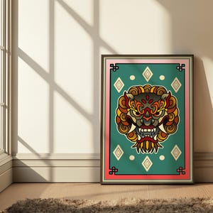 May include: Framed art print featuring a detailed illustration of a mythical creature's face. The artwork has a teal background with diamond shapes and a pink border. The creature's face is in shades of red, yellow, and brown.