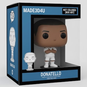 Puede incluir: Una figura de vinilo de Donatello en una caja de exhibición. La figura tiene una cabeza grande y ojos negros, vistiendo un uniforme blanco con los brazos cruzados. La caja es azul y negra con el texto "MADE3D4U" y "NOT COLORED (BOX ART)".