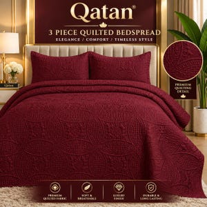 May include: A three-piece burgundy quilted bedspread set featuring a repeating circular and floral pattern. The set includes a large bedspread and two matching pillow shams, all displaying a textured, stitched design throughout the fabric.