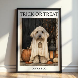 Puede incluir: Una lámina enmarcada que muestra a un perro de pelaje claro vestido con un disfraz de fantasma blanco. El texto TRICK OR TREAT aparece arriba y COCKA-BOO abajo. La escena incluye una puerta negra, calabazas naranjas y un farol encendido.