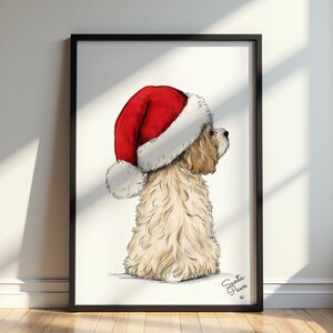 May include: A framed art print featuring a light brown, fluffy dog viewed from behind, wearing a large red and white Santa hat. The dog is looking toward the right side of the frame. The text Santa Paws is written in black in the bottom right corner.