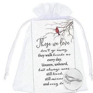 May include: A white satin bag with a small card inside. The card has a red cardinal perched on a bare branch with the text "Those we love don't go away, they walk beside us every day. Unseen, unheard, but always near still loved, still missed and very de" printed on it. A silver tone charm with a dove design is included.