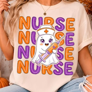 May include: A cream-colored t-shirt featuring a graphic of a white ghost wearing a nurse cap and holding a syringe. The word NURSE is repeated in a wavy pattern behind the ghost in alternating orange and purple text with a bold outline.