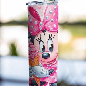 Peut inclure: Un gobelet rose et blanc avec Minnie Mouse tenant un cornet de glace. Le gobelet a une paille en acier inoxydable et un couvercle. Le motif comprend un grand n&oelig;ud rose et une robe rose. Le gobelet est cylindrique.
