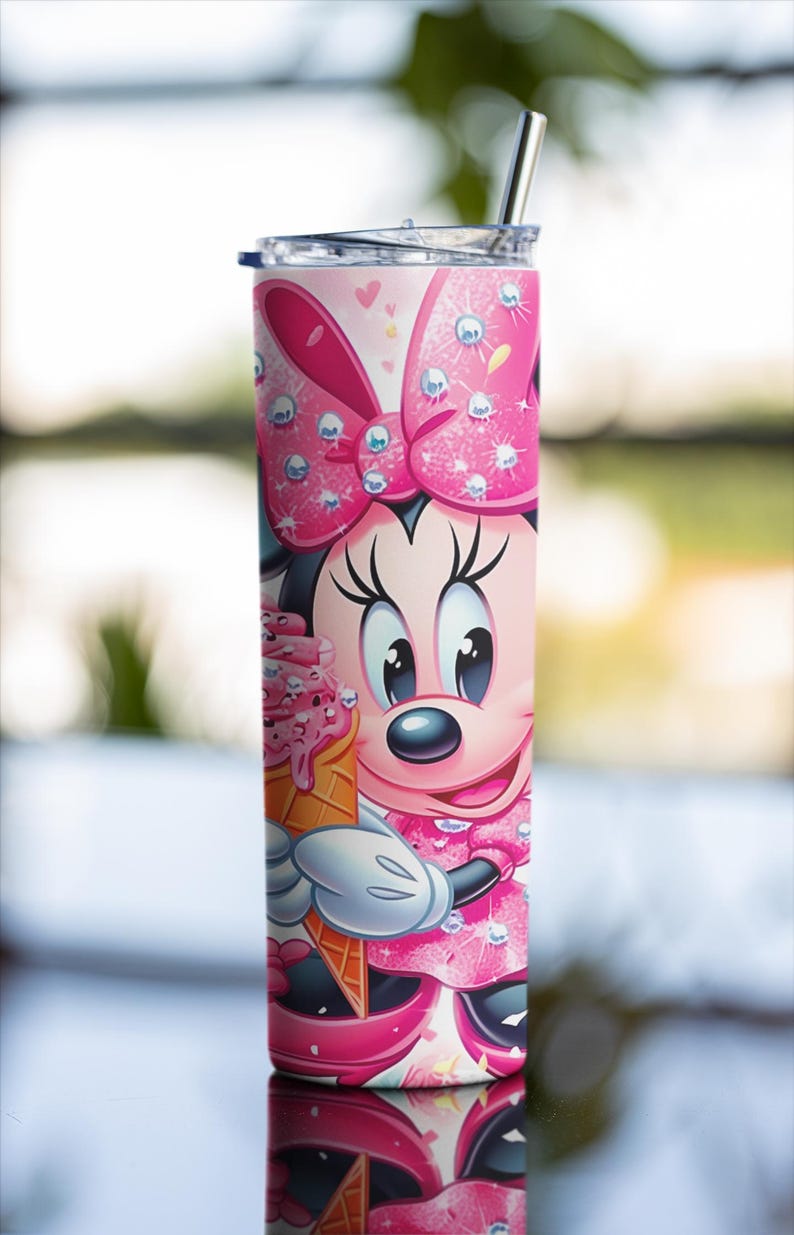 Peut inclure: Un gobelet rose et blanc avec Minnie Mouse tenant un cornet de glace. Le gobelet a une paille en acier inoxydable et un couvercle. Le motif comprend un grand n&oelig;ud rose et une robe rose. Le gobelet est cylindrique.
