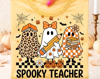 May include: A light yellow t-shirt featuring a graphic of three ghosts. One ghost has a leopard print pattern and a book on its head, one wears a polka dot bow and holds a pencil, and one has a checkered pattern and holds a stack of books. The text reads SPOOKY TEACHER.