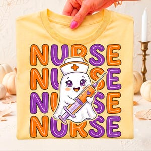 May include: A pale yellow t-shirt featuring the word NURSE repeated four times in alternating orange and purple bubble letters. In the center, a white ghost character wears a nurse cap with a cross and holds a large orange and purple syringe.