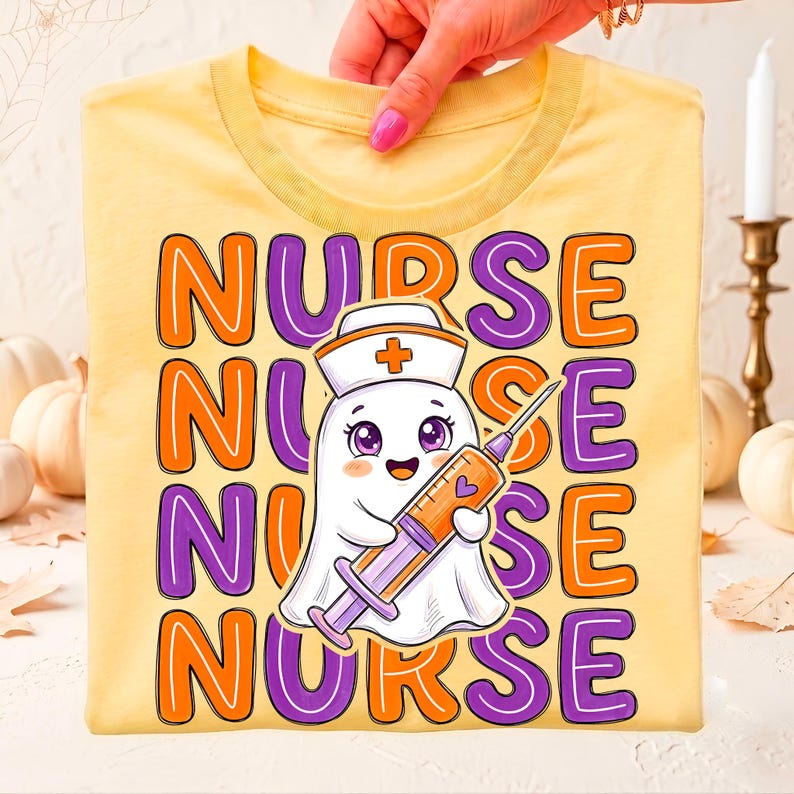 May include: A pale yellow t-shirt featuring the word NURSE repeated four times in alternating orange and purple bubble letters. In the center, a white ghost character wears a nurse cap with a cross and holds a large orange and purple syringe.