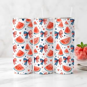 May include: Three white insulated tumblers with a repeating pattern of watermelon slices, red and blue bows, hearts, and stars. Each tumbler has a white straw.