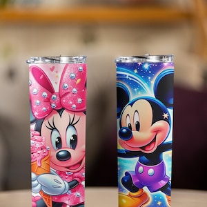 Peut inclure: Deux gobelets en acier inoxydable avec des personnages Disney. L'un pr&eacute;sente Minnie Mouse en rose avec un cornet de glace, l'autre Mickey Mouse en bleu et violet. Les deux gobelets ont des couvercles transparents et sont isol&eacute;s.