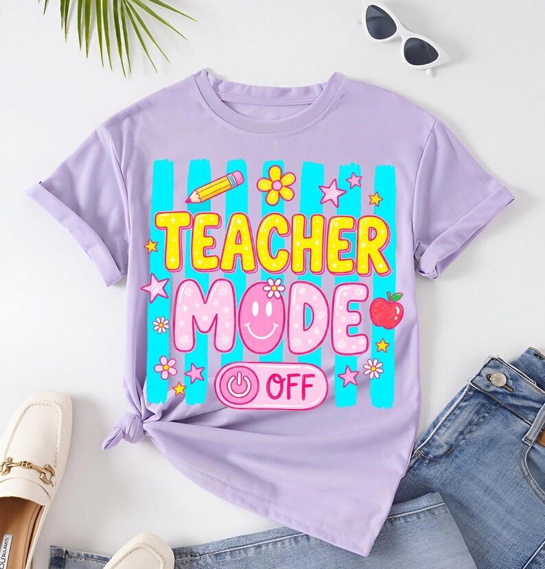 May include: A lilac-colored t-shirt with the words "TEACHER MODE OFF" in a colorful, playful font. The design includes a pencil, flowers, stars, a smiling face, and an apple. The shirt is styled with jeans and loafers.