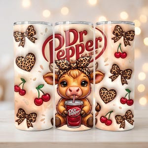 May include: A set of three stainless steel tumblers with a Dr. Pepper theme. Each tumbler features a repeating pattern of leopard print bows, hearts, and cherries. The center tumbler has a cartoon cow drinking from a Dr. Pepper cup.