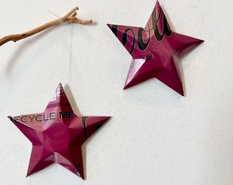 May include: Two burgundy star-shaped ornaments made from recycled aluminum cans. The top ornament has the text "Recycle Me" and the bottom ornament has the text "Cool Sugar".