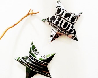 May include: Two green and white star-shaped ornaments made from recycled aluminum cans. The larger star has the text "Old Chub Scotch Ale" printed on it. The smaller star has the text "Scotch Ale" and "Pack it in Pack it out" printed on it.