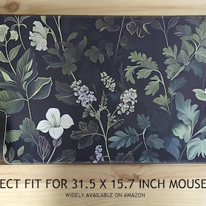 May include: A rectangular mousepad with a dark background and a floral design featuring white, green, and gray leaves and flowers. The mousepad measures 31.5 x 15.7 inches.