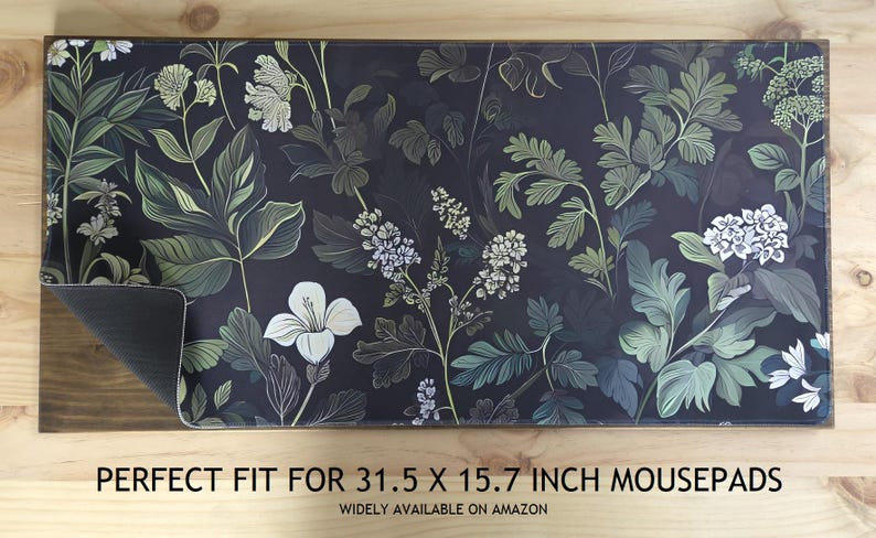 May include: A rectangular mousepad with a dark background and a floral design featuring white, green, and gray leaves and flowers. The mousepad measures 31.5 x 15.7 inches.