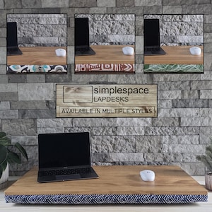 May include: A wooden lap desk with a navy blue and white chevron patterned cushion base. The desk surface holds a laptop and a white computer mouse. A text overlay reads simplespace LAPDESKS AVAILABLE IN MULTIPLE STYLES with three inset images showing alternative cushion patterns.