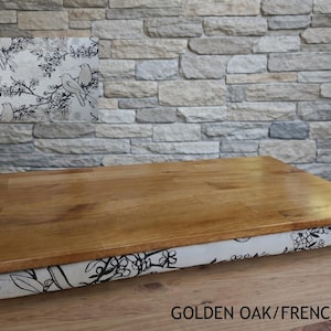 May include: A rectangular wooden lap desk with a golden oak finish. The base is covered in fabric with a black and white bird and floral pattern. The text "GOLDEN OAK/FRENCH DOVES" is at the bottom.