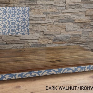 May include: A wooden serving tray with a dark walnut finish. The tray's edge is wrapped in fabric with a blue and white scroll pattern. The text "DARK WALNUT/IRONWORK VINE" is visible at the bottom.