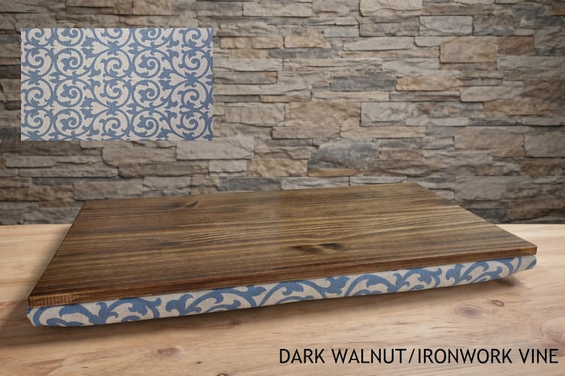 May include: A wooden serving tray with a dark walnut finish. The tray's edge is wrapped in fabric with a blue and white scroll pattern. The text "DARK WALNUT/IRONWORK VINE" is visible at the bottom.