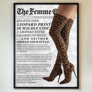 May include: A framed print featuring a newspaper-style design with the headline "The Femme C" and the text "Leopard Print is Wildly Chic." The image showcases a pair of leopard-print thigh-high boots. The boots have high heels and a pointed toe.