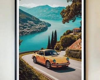 May include: Framed art print showing a classic yellow sports car on a scenic road beside a turquoise lake. The image includes mountains, trees, and a village. The artwork is presented in a black frame.