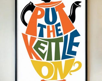 May include: A framed art print with the words "PUT THE KETTLE ON" in colorful, stylized lettering. The design incorporates a teapot and teacup shape, with orange, blue, green, and yellow hues against a white background.