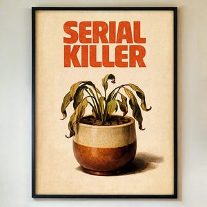 May include: Framed art print featuring the words "SERIAL KILLER" in orange block letters above a potted plant with drooping, dried leaves. The pot is two-toned, with a beige upper section and a brown base.