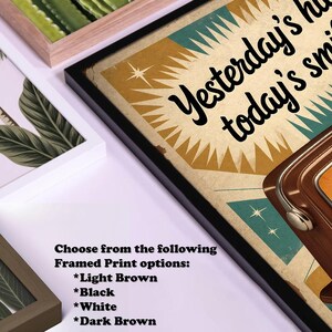May include: Framed art print with the text "Yesterday's happy, today's smile" in a retro style. The print is in a black frame, with options for light brown, black, white, and dark brown frames. Other framed art prints are visible.