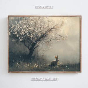 May include: A framed print of a painting depicting a white-flowered tree in a misty forest with a small rabbit sitting in the grass.