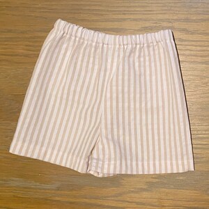May include: Beige and white striped cotton shorts with an elastic waistband.