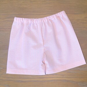 May include: Pink and white striped shorts with a white elastic waistband.