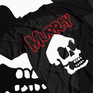 May include: Black t-shirt with a red "MURRAY" graphic and a white skull graphic.