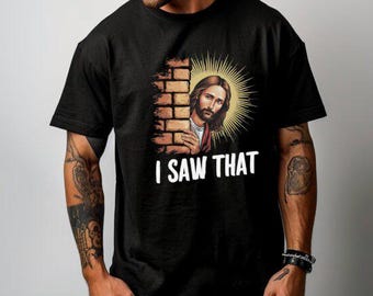 May include: A black t-shirt with a graphic of Jesus peeking around a brick wall. The text "I saw that" is printed below the image.