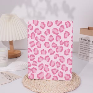 May include: Pink and white leopard print laptop skin. The skin is a sticker that can be applied to the back of a laptop.