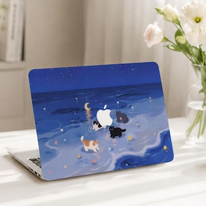 May include: A laptop skin featuring a dark blue night sky and ocean scene with four small cats wading in shallow water. The design includes a crescent moon, scattered yellow stars, and the white Apple logo integrated into the center.