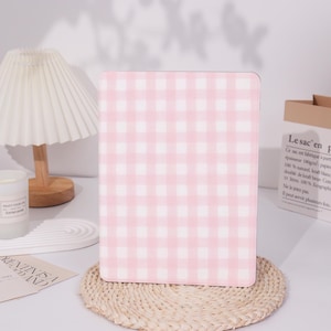 May include: A pink and white checkered notebook cover. The cover is made of a soft, durable material and is perfect for protecting your notebook.