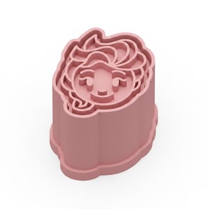 May include: A light pink cookie cutter in the shape of a cartoon face with a smiling expression. The cutter has a detailed design of the face, including the hair, eyes, and mouth. The cutter is made of plastic and is designed for use in baking.