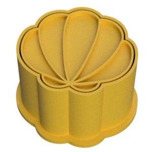 May include: A yellow, flower-shaped cookie cutter. The cutter has a rounded base and a scalloped edge. The top of the cutter has a petal design. The cutter is made of a solid, opaque material.