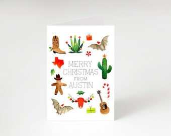 May include: A white Christmas card with a watercolor illustration of a cowboy boot, a cactus, a gingerbread man, a guitar, a bull, a bat, a candy cane, a Texas state outline, and a Christmas tree. The text on the card reads "Merry Christmas from Austin".