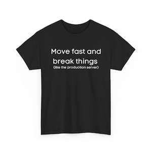 Puede incluir: Camiseta negra con texto blanco: "Move fast and break things (like the production server)". La camiseta tiene cuello redondo y mangas cortas. El texto está centrado en la parte delantera.