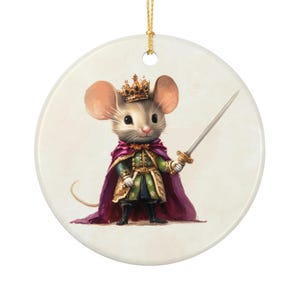 Pode incluir: Enfeite de Natal redondo em cerâmica com uma ilustração de um rato real. O rato usa uma coroa de ouro, uma capa roxa e segura uma espada. O enfeite tem um cordão dourado para pendurar.