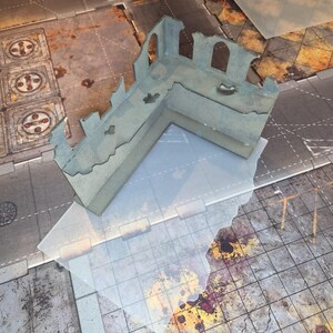 May include: An L-shaped miniature wargaming terrain piece featuring a ruined concrete wall structure with arched window cutouts and jagged, weathered edges. The model is painted in muted grey tones with subtle blue undertones and distressed textures.