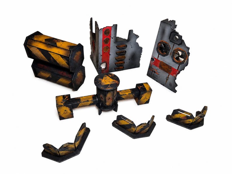 May include: A collection of miniature wargaming terrain pieces featuring industrial ruins, barricades, and pipes. The items are painted with weathered yellow and black hazard stripes, grey concrete textures, and red accents on the wall sections.
