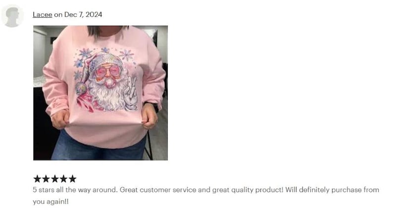 a woman wearing a pink sweatshirt with a santa clause on it