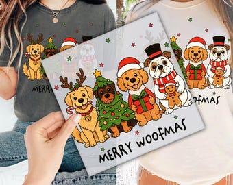 May include: A light gray t-shirt and a cream-colored sweatshirt featuring a "Merry Woofmas" design. The design includes cartoon dogs wearing Santa hats, holding gifts, and decorated as a Christmas tree. Green stars and text complete the festive look.