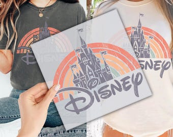 May include: Two women wearing t-shirts with a vintage-style rainbow and Disney castle graphic. The text "Disney" is in a distressed font.